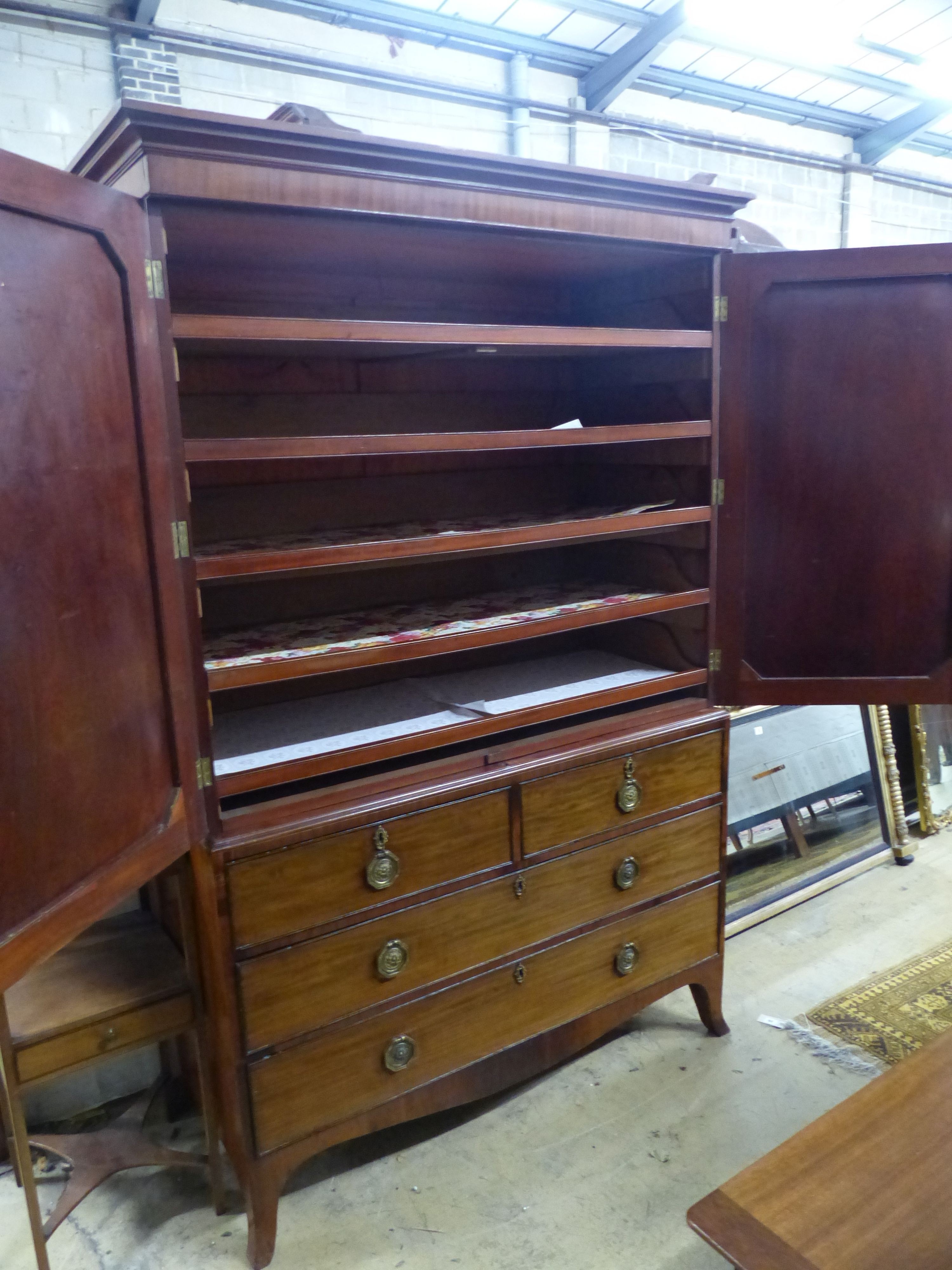 A George IV mahogany linen press, with a pair of hinged panelled doors over two short and two long drawers, on splay feet W.132 D.58 H.202 cms